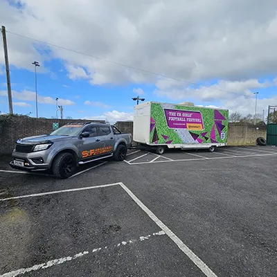 a truck parked in a parking lot next to a trailer