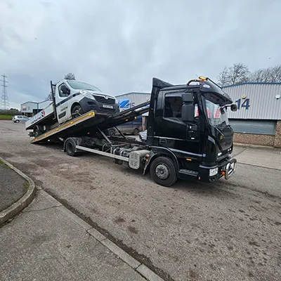 a tow truck with a car on the back of it