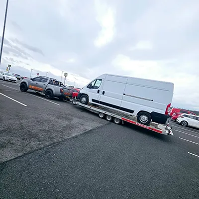 a white van being towed by a tow truck