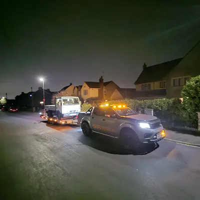 a truck and a car on a street at night