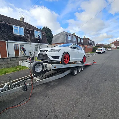 a white car is being towed on a trailer